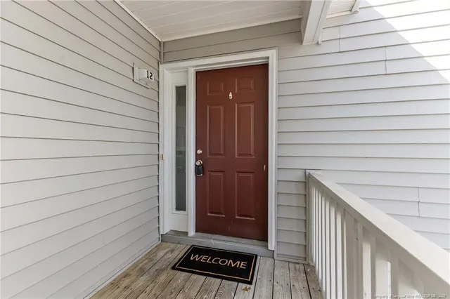 a view of a white building among the street with palm trees