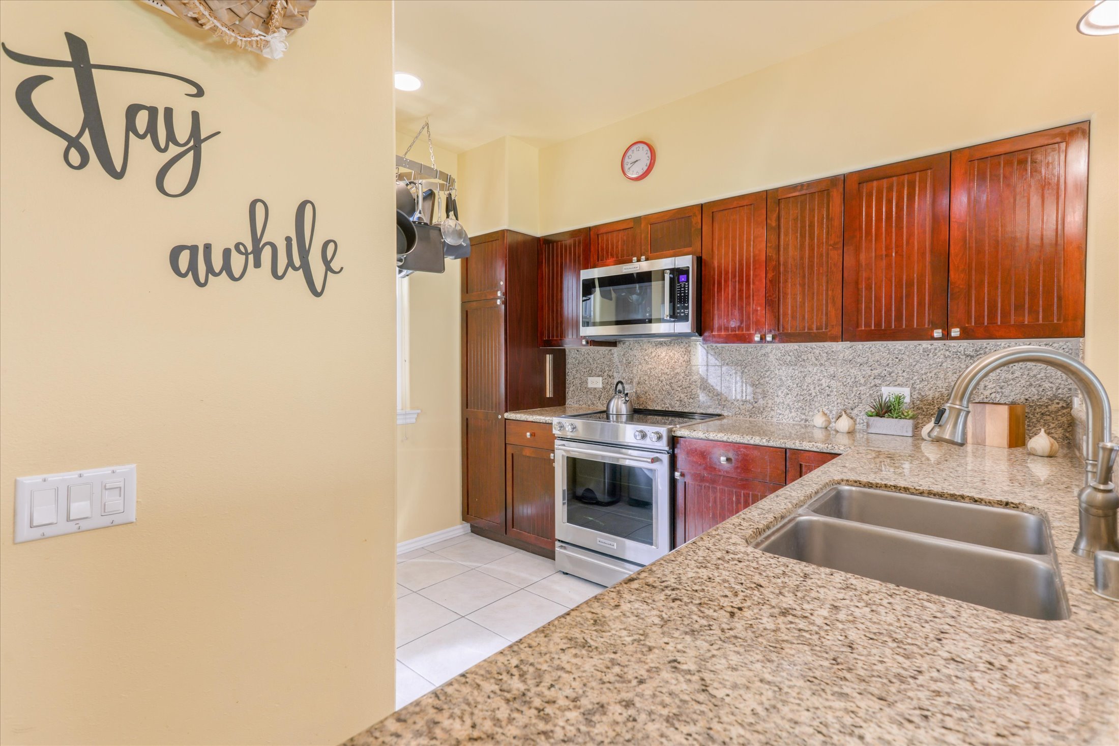 69-200 Pohakulana Place, Unit G5 Waikoloa, HI 96738 - Photo 5 of 27 a kitchen with granite countertop a sink stove and refrigerator
