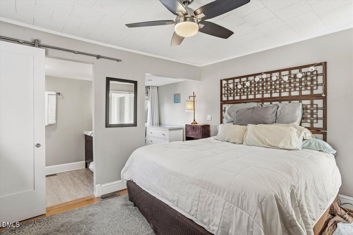 1005 West Main Street Carrboro, NC 27510 - Photo 10 of 27 a bedroom with a large bed and a chandelier