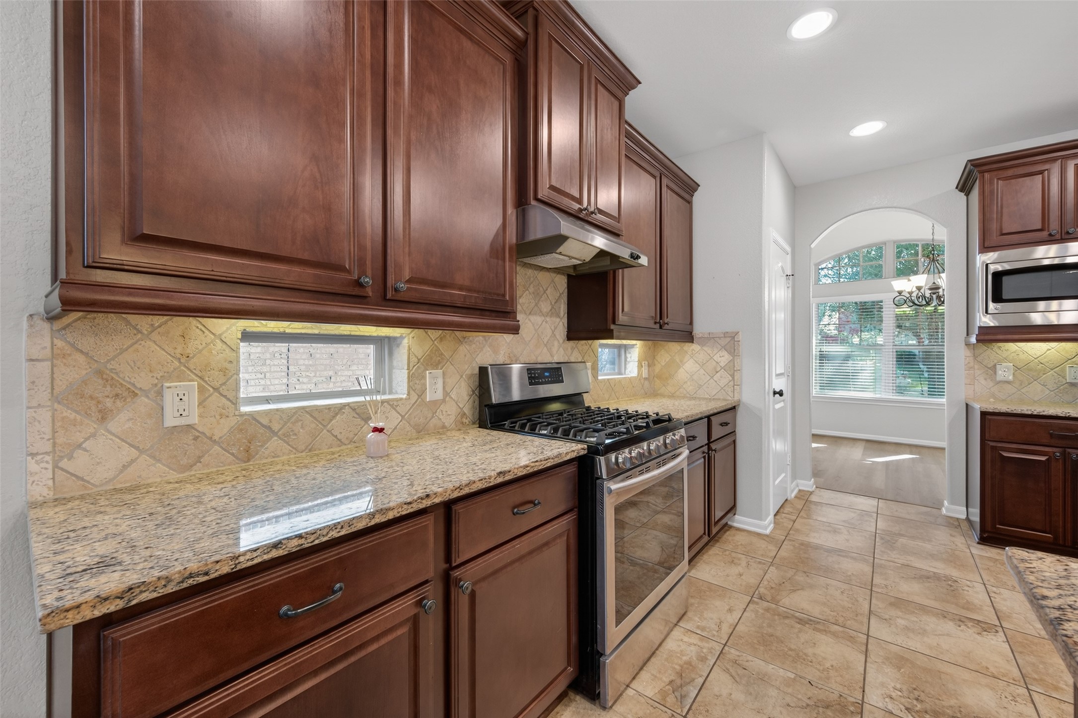 6 Painted Post Place Spring, TX 77389 - Photo 19 of 49 a kitchen with granite countertop stainless steel appliances and wooden cabinets