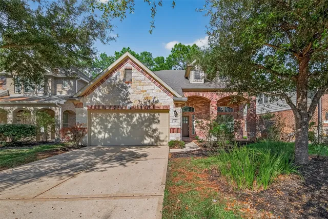 a view of a house next to a yard with big trees