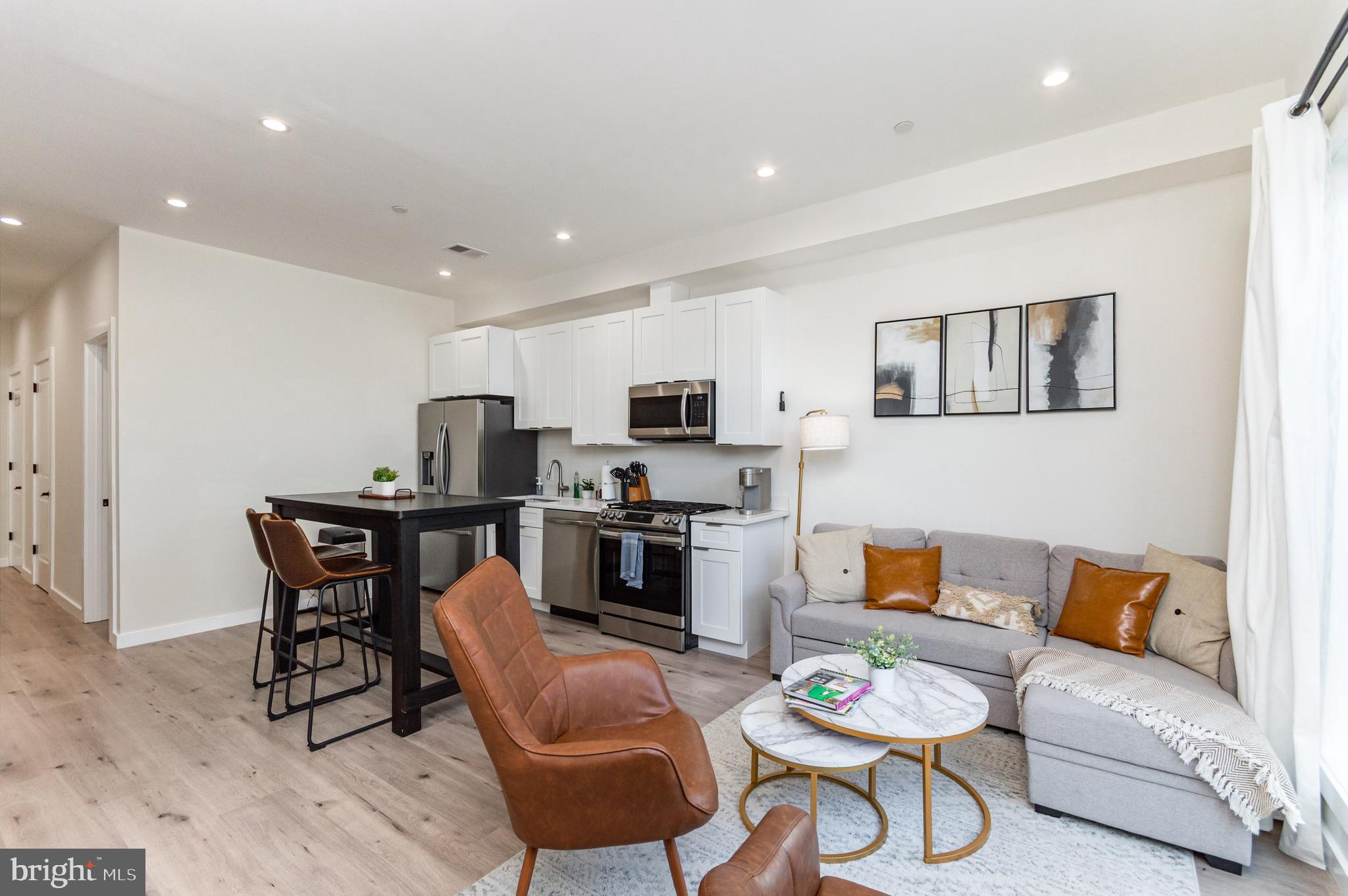 2116 4th Street Northeast, Unit A Washington, DC 20002 - Photo 14 of 17 a living room with furniture a flat screen tv and kitchen view