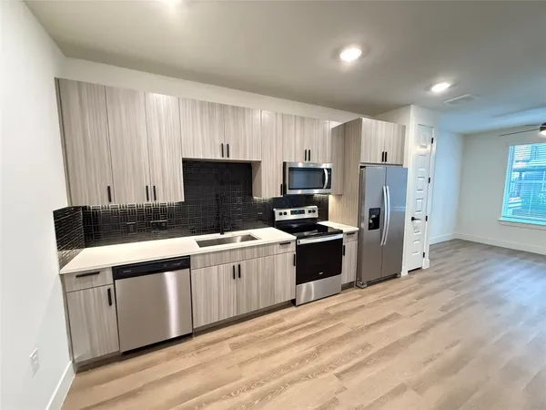 a kitchen with stainless steel appliances granite countertop a stove a sink dishwasher a refrigerator and a microwave
