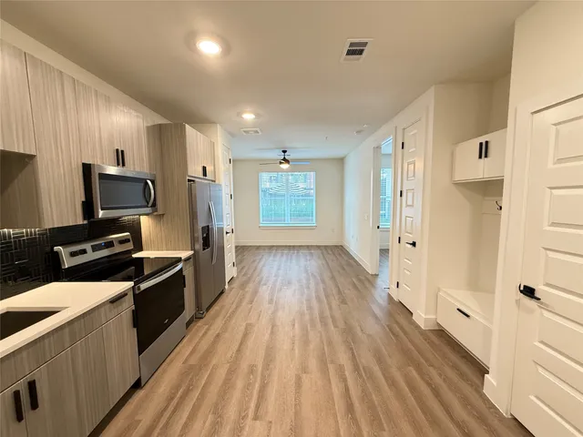 a kitchen with wooden floor and stainless steel appliances