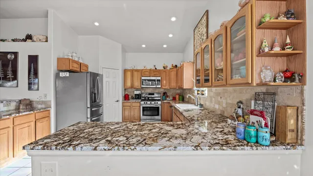 a kitchen with stainless steel appliances granite countertop a sink stove and refrigerator