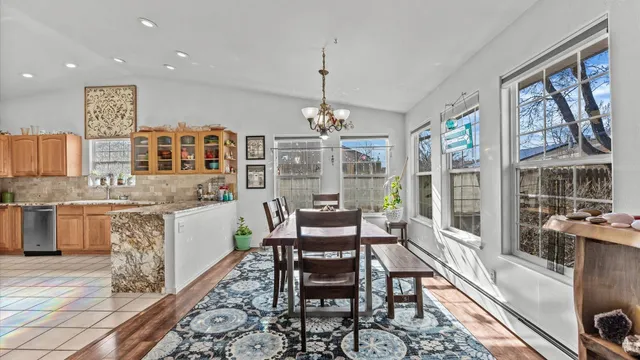 a dining room with furniture a chandelier and wooden floor