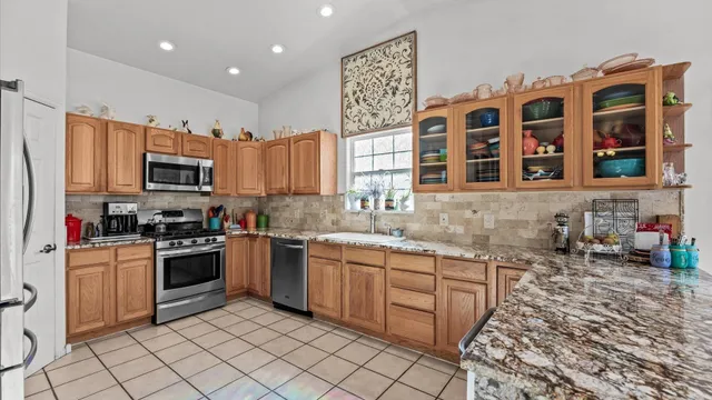 a kitchen with stainless steel appliances granite countertop a stove sink and cabinets