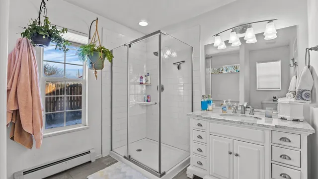 a bathroom with a shower sink and mirror