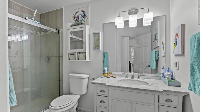 a bathroom with a granite countertop sink toilet a large mirror a shower and vanity