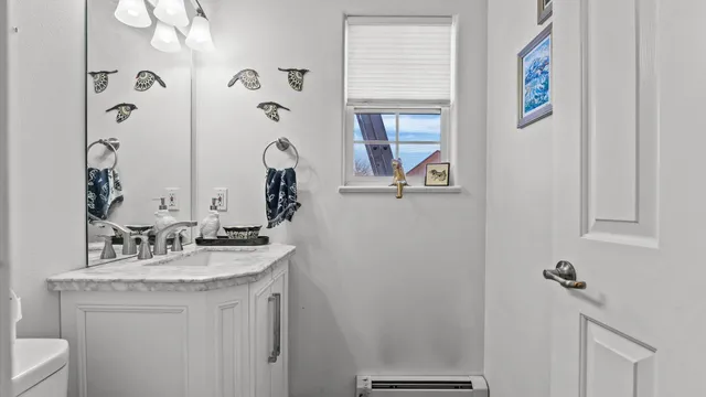 a bathroom with a granite countertop sink a toilet and a mirror