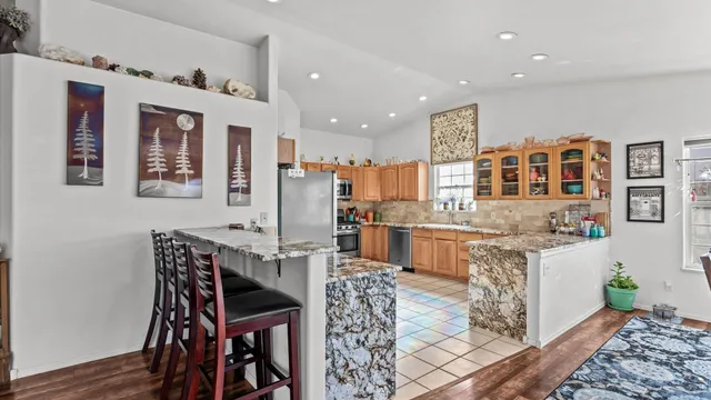 a kitchen with stainless steel appliances granite countertop a table and chairs