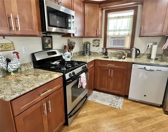 a kitchen with stainless steel appliances granite countertop a stove a sink and a microwave