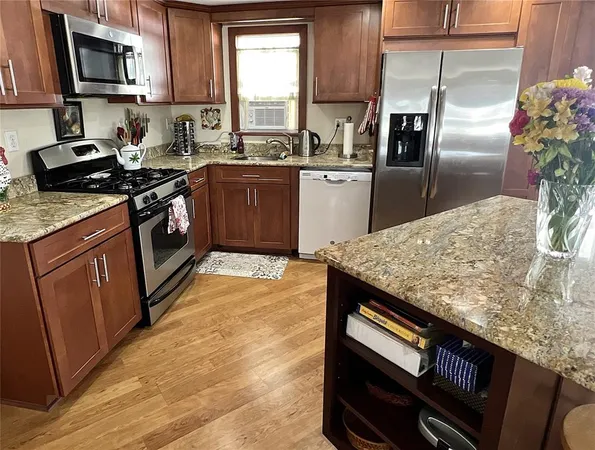 a kitchen with stainless steel appliances granite countertop a sink stove and refrigerator