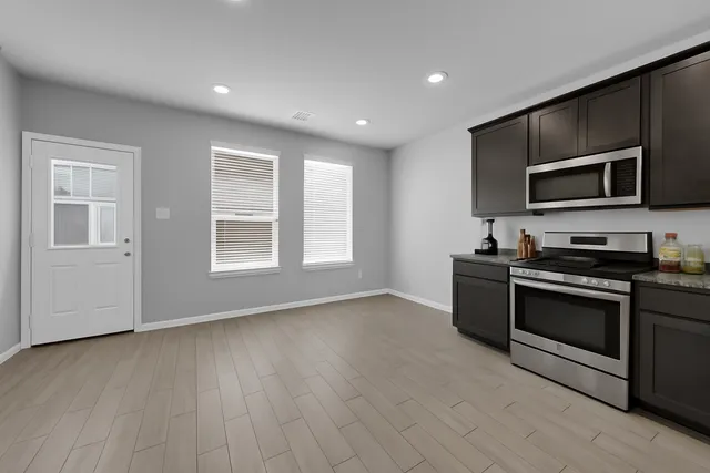 a kitchen with stainless steel appliances granite countertop a stove and a microwave