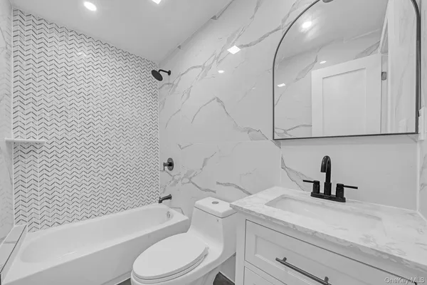 a bathroom with a sink a toilet a mirror and shower