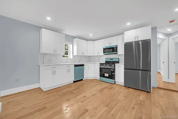 a kitchen with granite countertop a refrigerator and a stove top oven