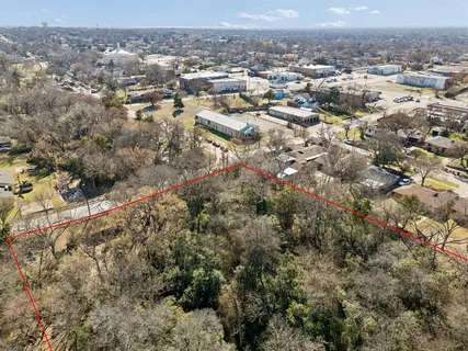 an aerial view of residential houses with city and green space