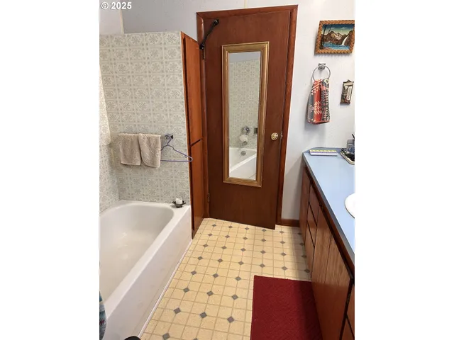 a bathroom with a bathtub sink and mirror