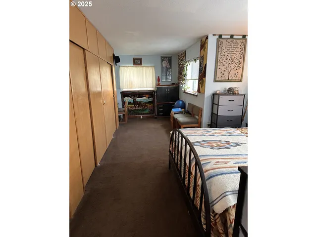 a view of a hallway to a livingroom with furniture and windows