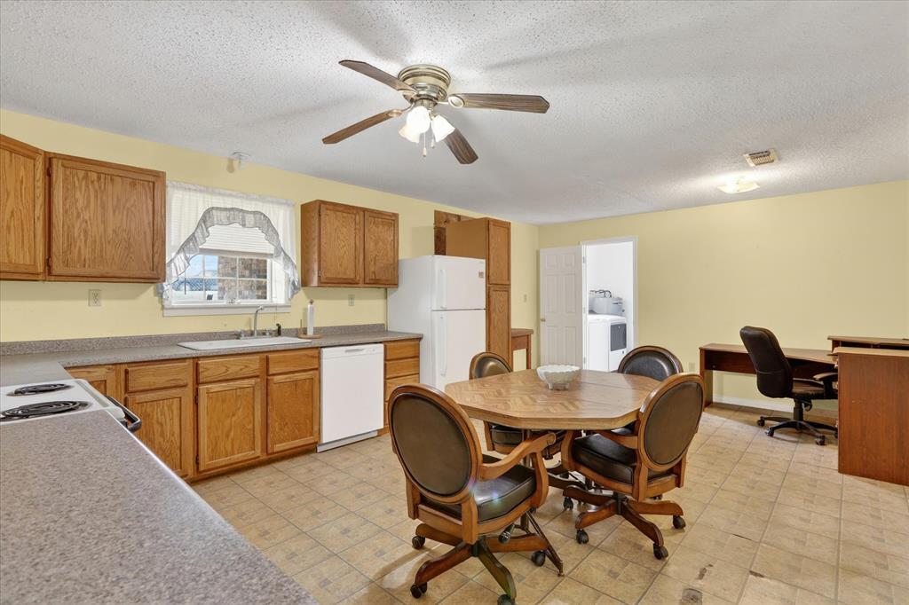 1092 West Highway 199 Springtown, TX 76082 - Photo 12 of 29 Open-concept kitchen featuring wood cabinetry, laminate countertops, a ceiling fan with integrated lighting, and tile flooring
