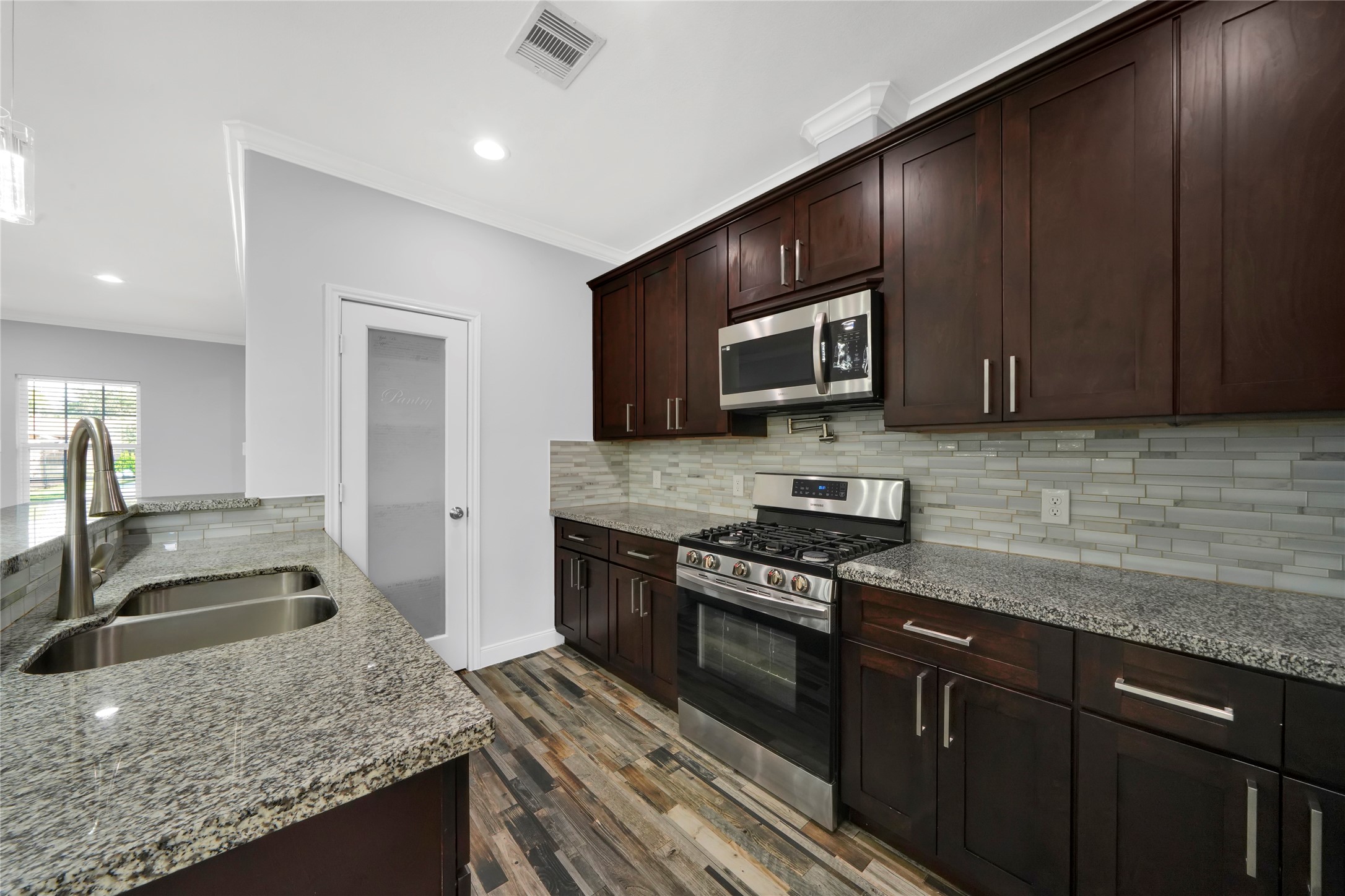 4732 Carmen Street, Unit A Houston, TX 77033 - Photo 12 of 26 a kitchen with granite countertop wooden cabinets and stainless steel appliances