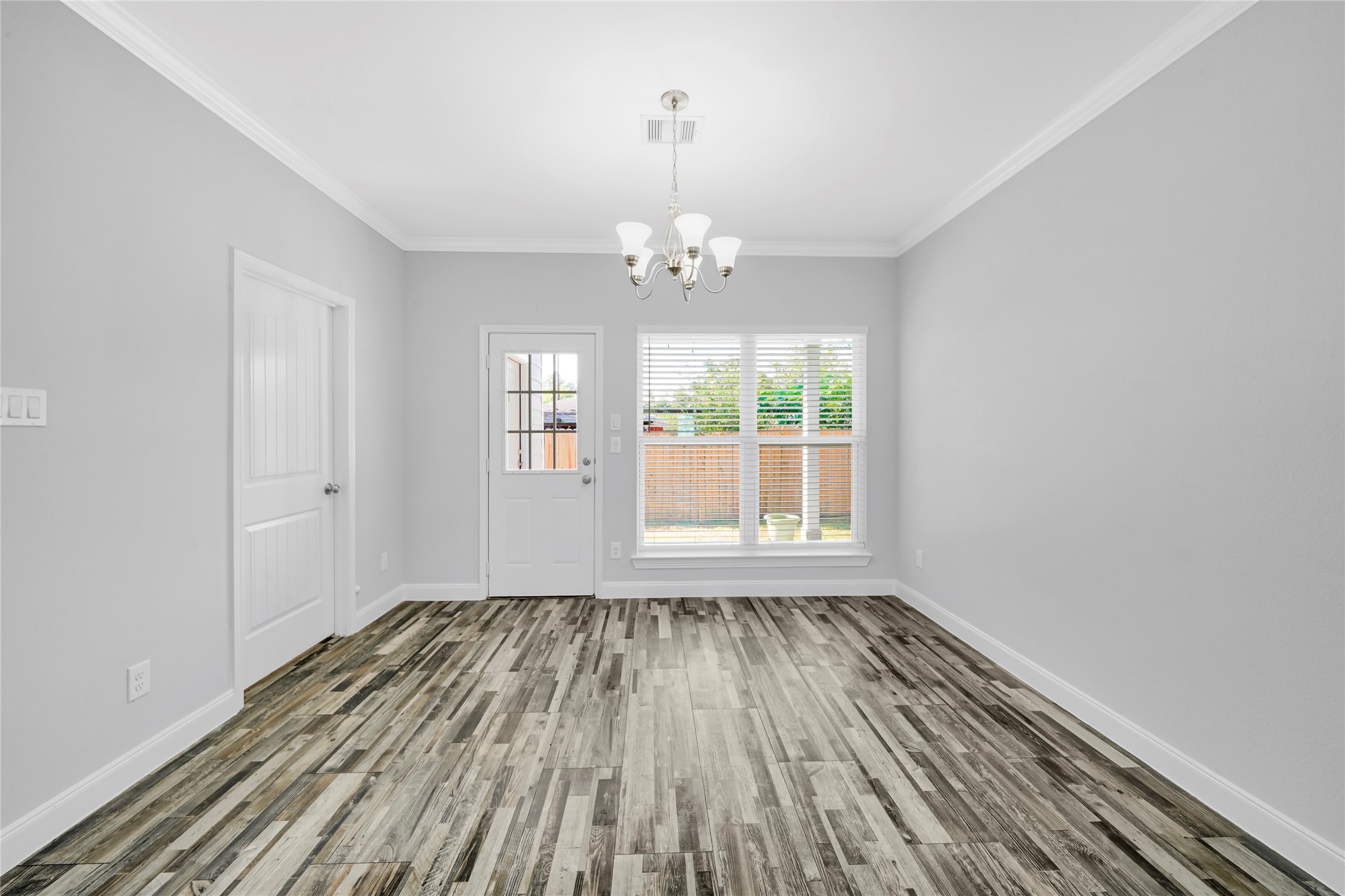 4732 Carmen Street, Unit A Houston, TX 77033 - Photo 7 of 26 a view of an empty room with wooden floor and a window