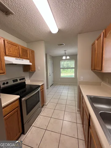 a kitchen with a stove top oven cabinets and a refrigerator