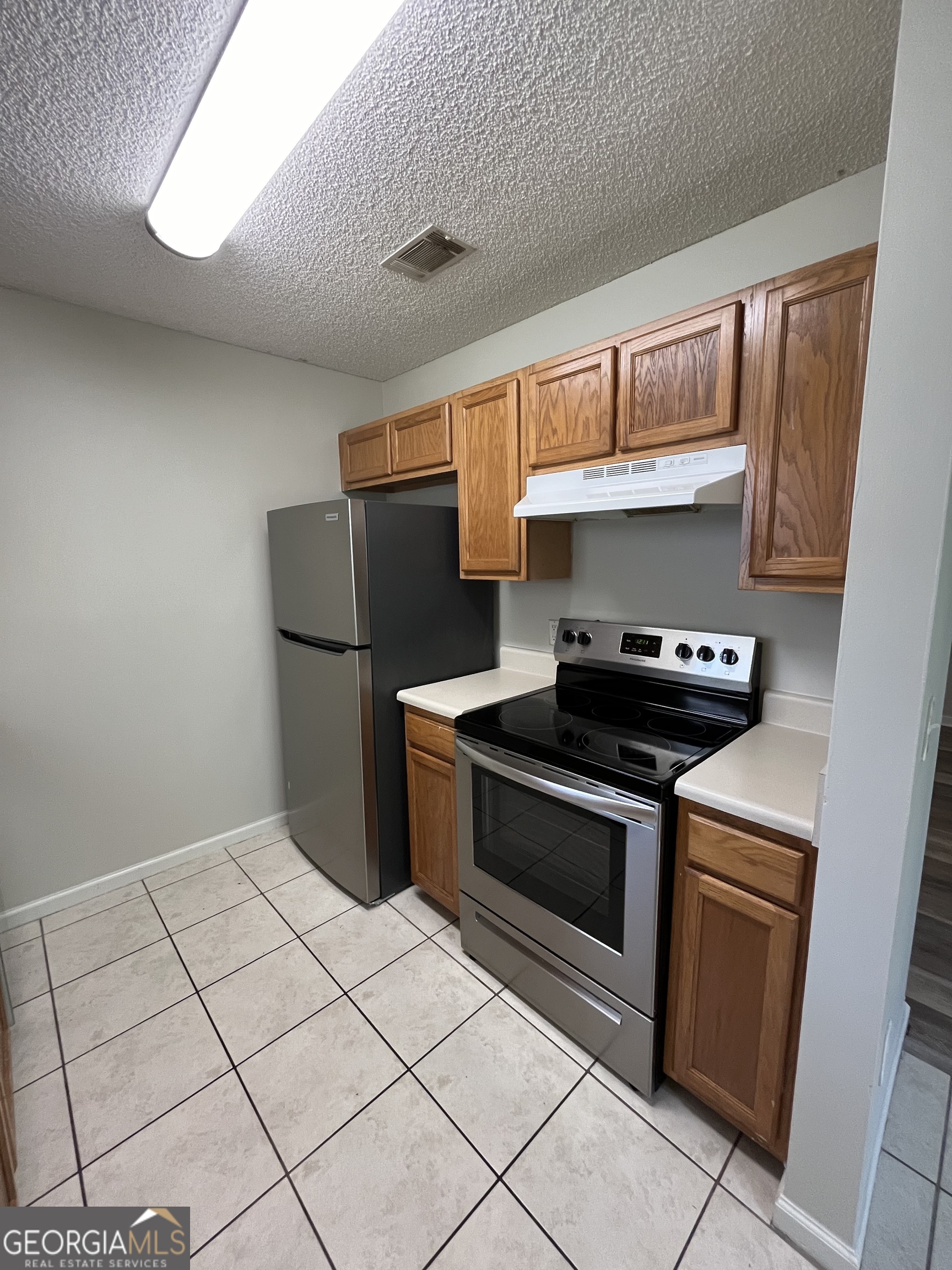 120 Sapelo Drive St. Marys, GA 31558 - Photo 13 of 24 a kitchen with a stove top oven cabinets and a refrigerator