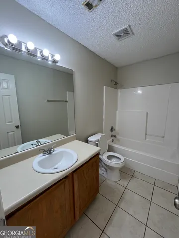 a bathroom with a sink a toilet and mirror