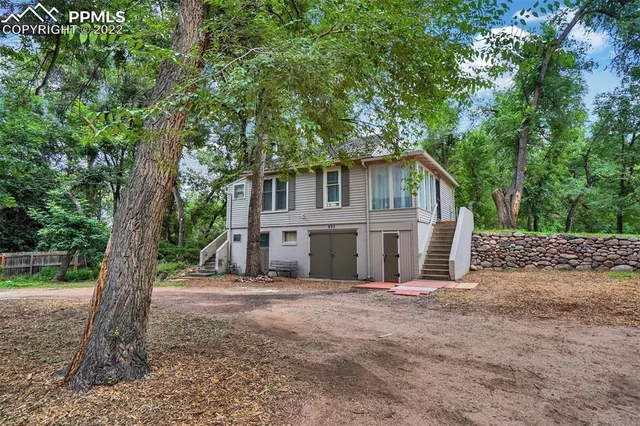 a front view of a house with a tree in front of it