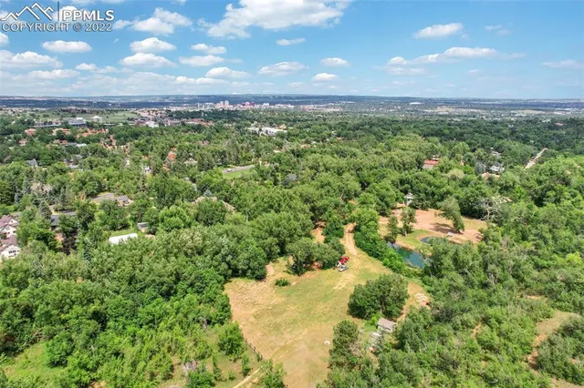 an aerial view of residential houses with outdoor space and trees