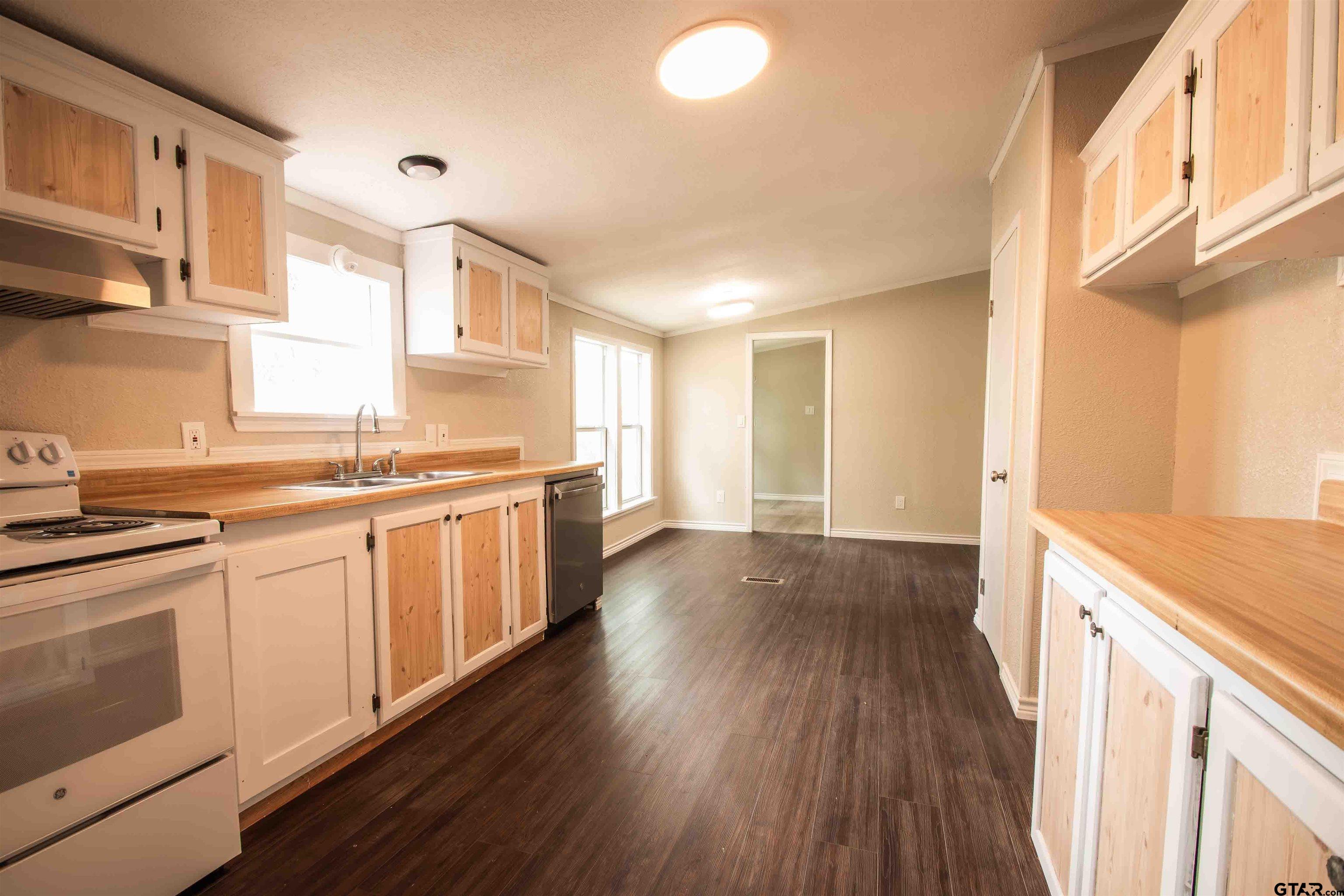 161 Clearview Circle Murchison, TX 75778 - Photo 20 of 47 a kitchen with stainless steel appliances granite countertop wooden floors and white walls
