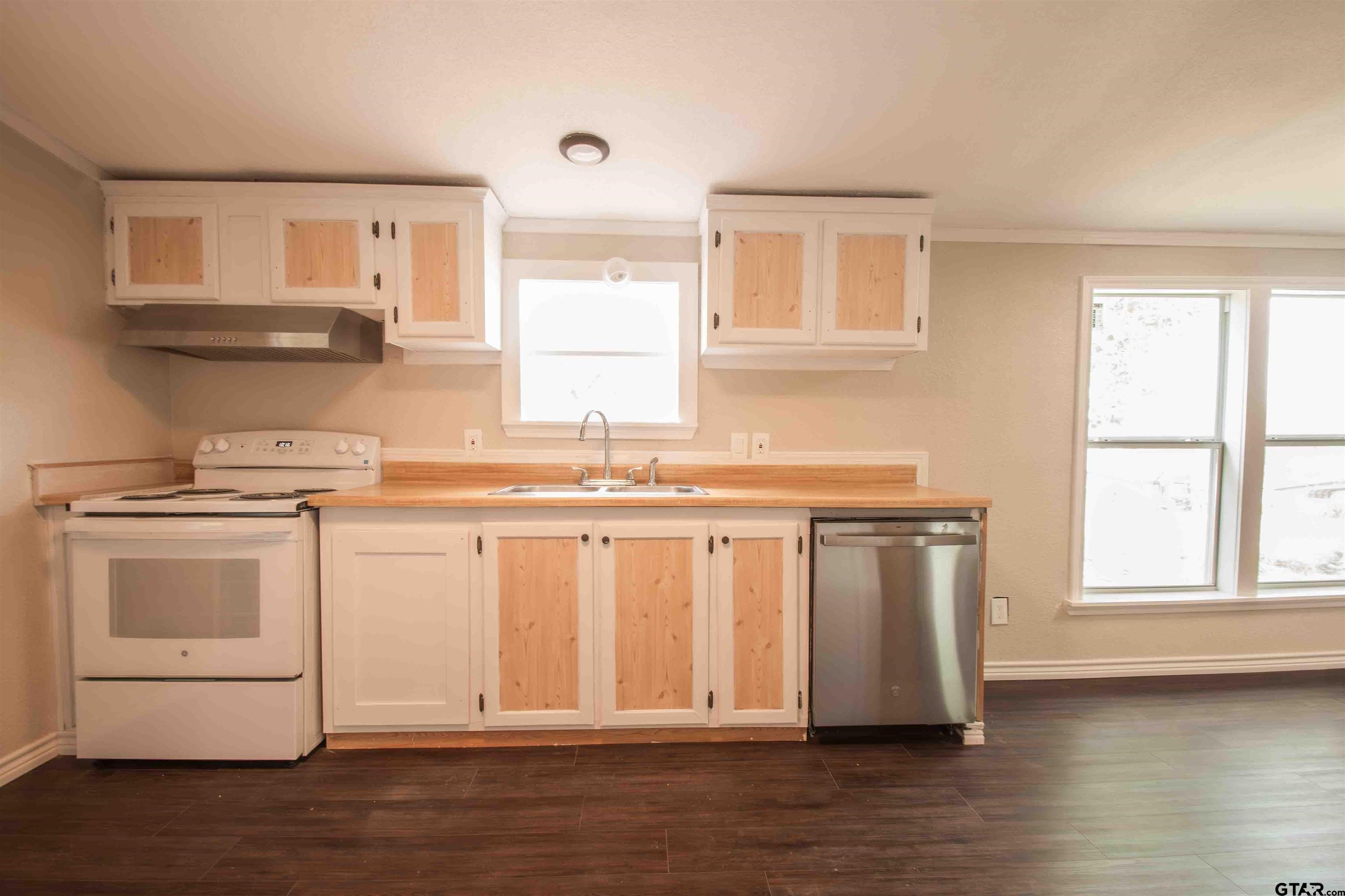 161 Clearview Circle Murchison, TX 75778 - Photo 22 of 47 a kitchen with granite countertop white cabinets and white appliances