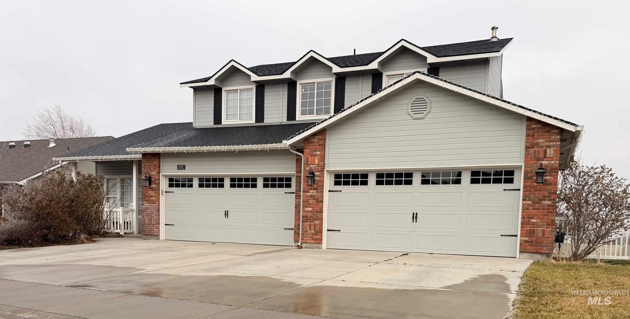 Traditional-style house with brick siding and concrete driveway