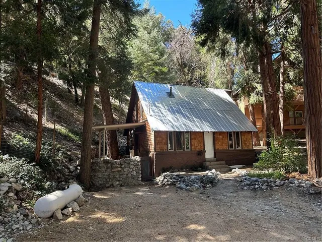 a view of a house with a yard and large tree