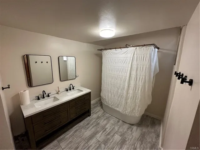 a bathroom with double vanity sink and mirror