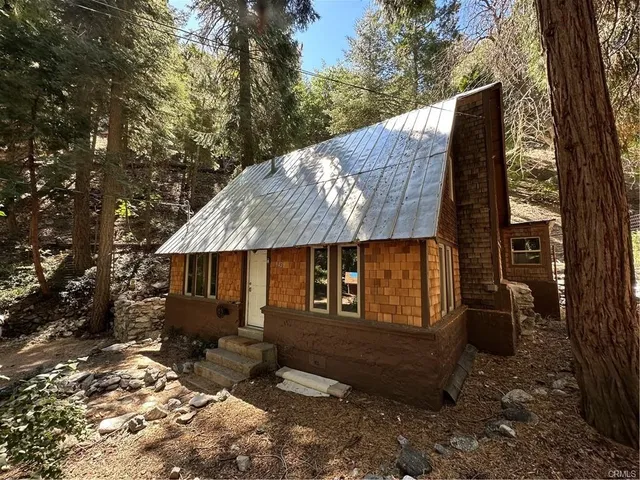 a backyard of a house with barbeque oven table and chairs under an umbrella