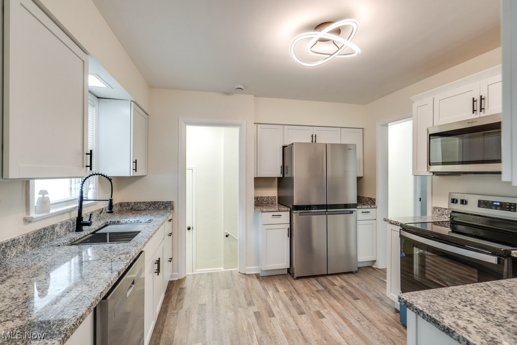 6961 Maplewood Road Parma Heights, OH 44130 - Photo 3 of 22 Kitchen with white cabinetry, stainless steel appliances, light hardwood / wood-style flooring, and sink