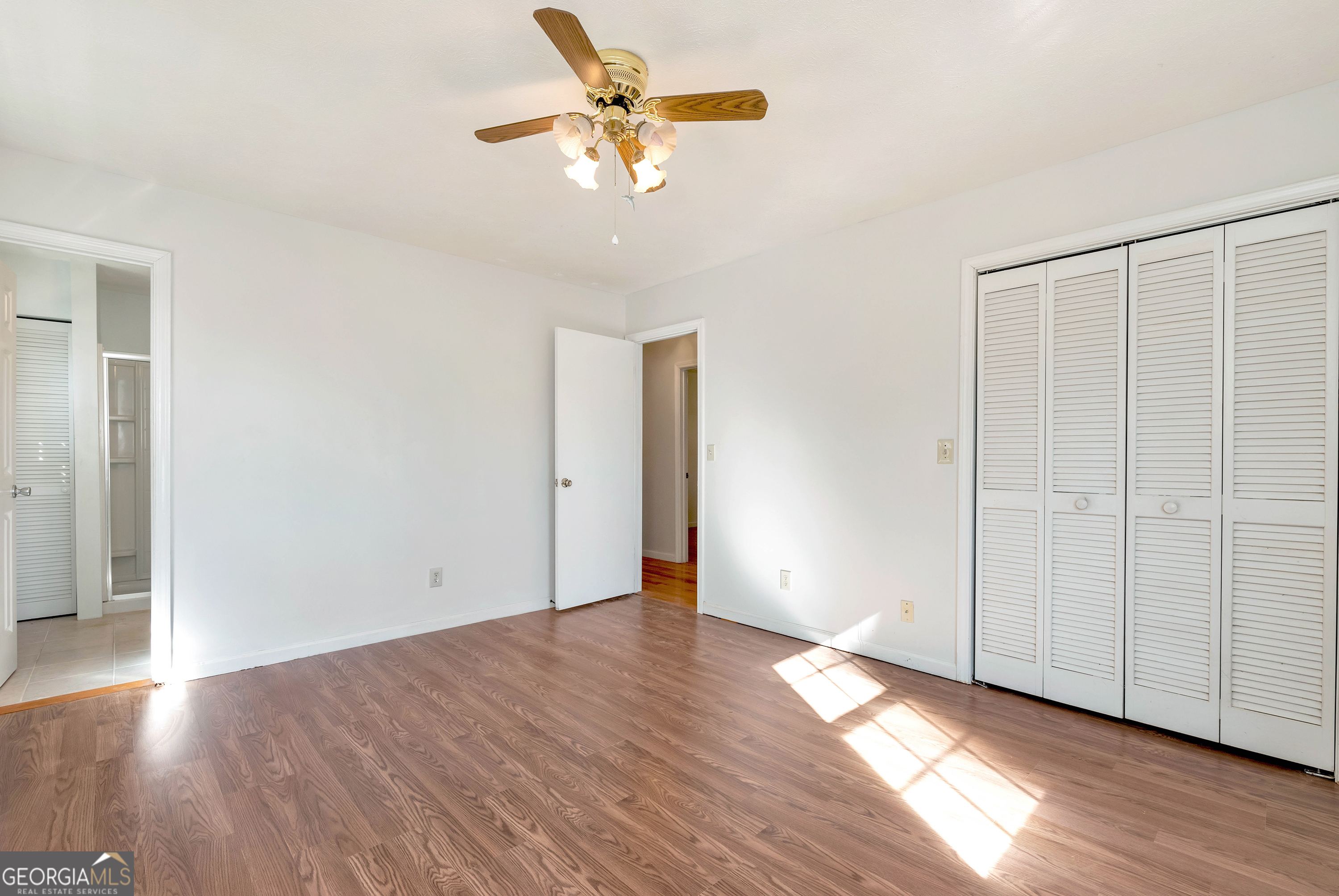 303 Jennys Cove Road Cleveland, GA 30528 - Photo 15 of 60 an empty room with wooden floor chandelier fan and windows