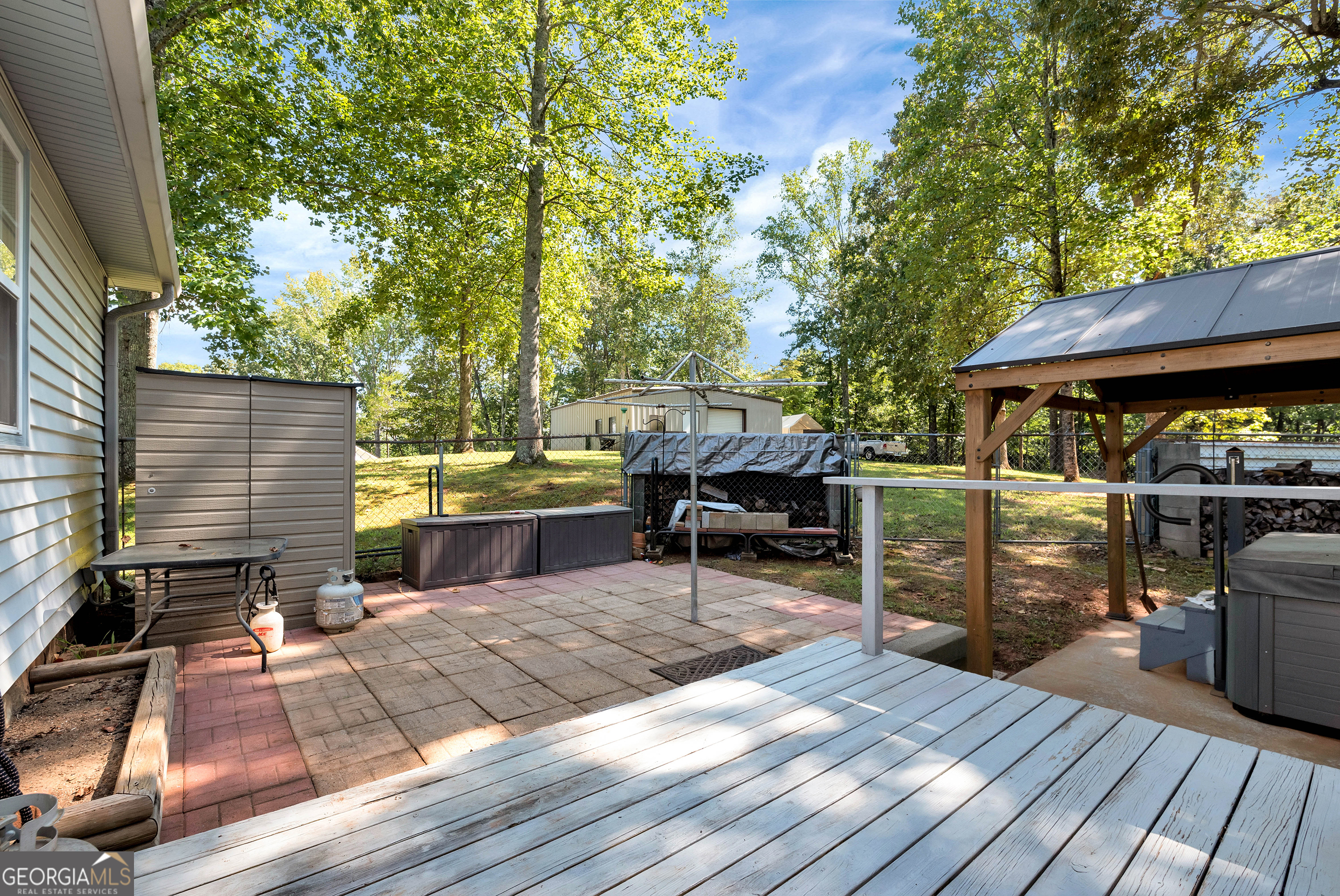 303 Jennys Cove Road Cleveland, GA 30528 - Photo 25 of 60 a view of a patio with table and chairs barbeque oven and a barbeque with wooden fence
