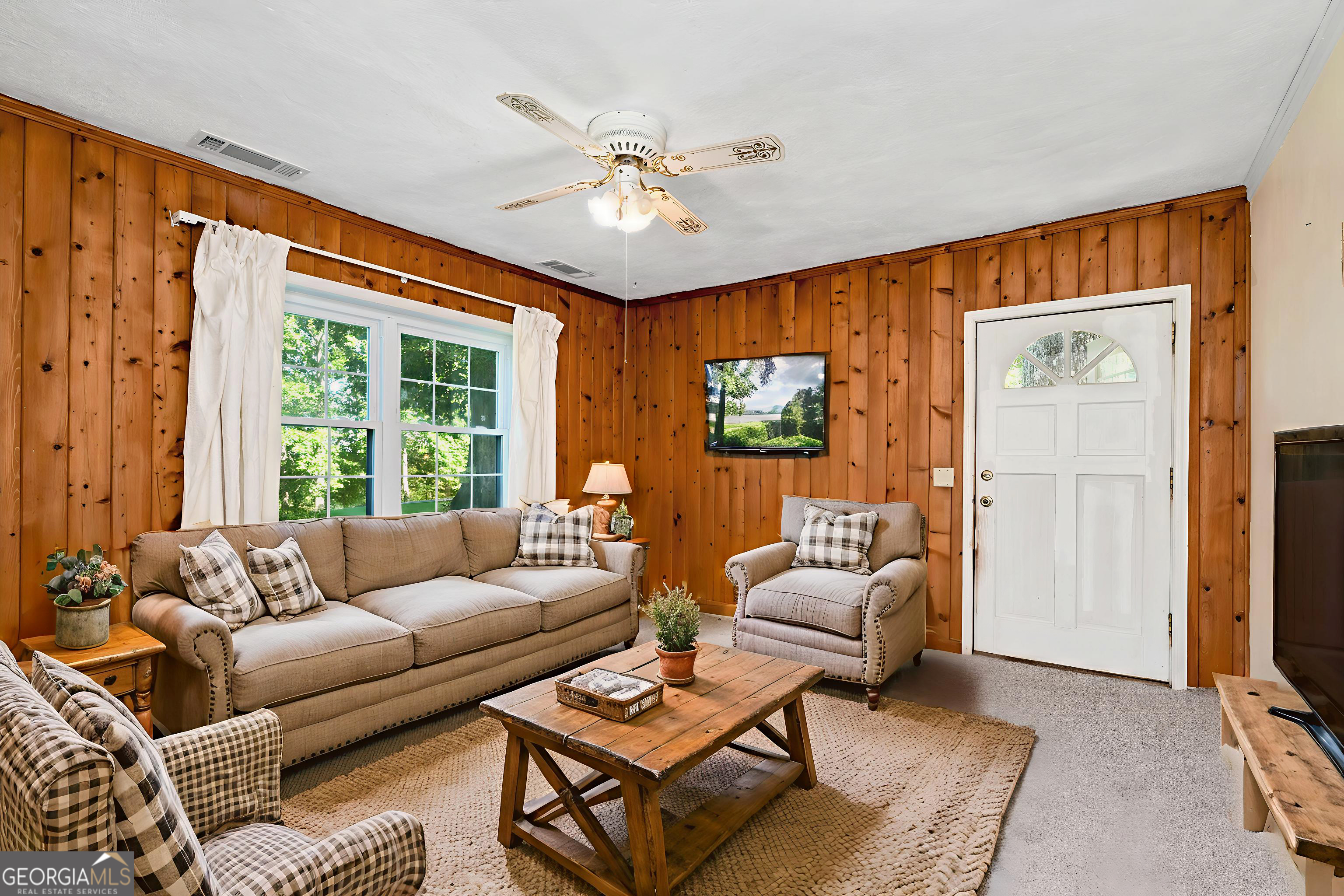 303 Jennys Cove Road Cleveland, GA 30528 - Photo 36 of 60 a living room with furniture a large window and a flat screen tv