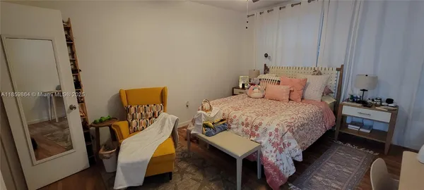 a bedroom with a bed a couch and dresser