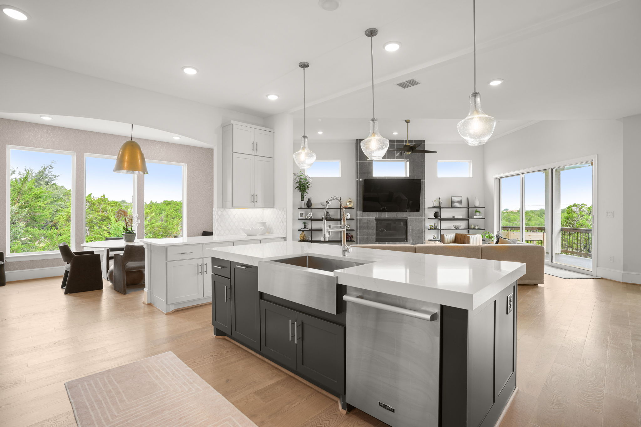 104 Lodestone Cove Austin, TX 78738 - Photo 1 of 40 A contemporary open-plan living space features a gourmet kitchen island with a farm sink, bathed in natural light.