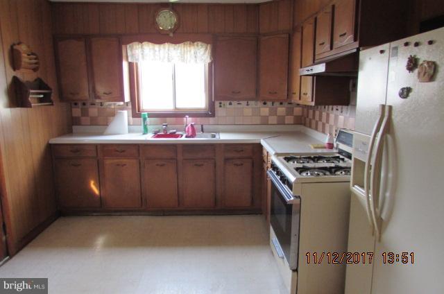 208 German Hill Road Baltimore, MD 21222 - Photo 9 of 24 a kitchen with stainless steel appliances a refrigerator a sink a stove and a refrigerator