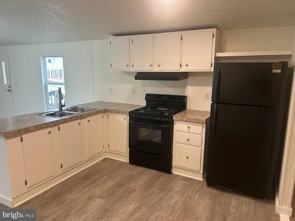 a kitchen with a refrigerator stove and white cabinets
