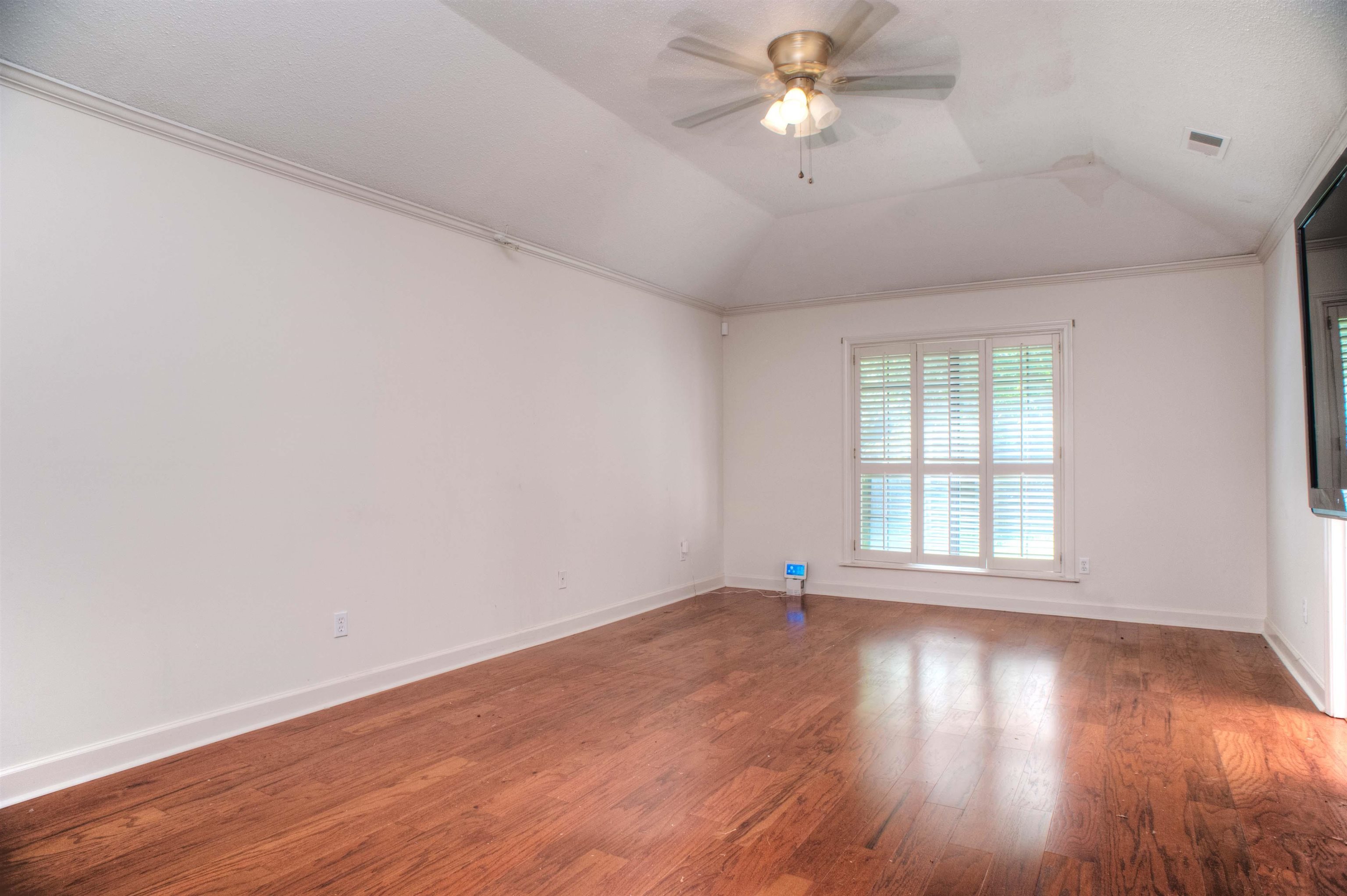 8225 Walnut Grove Road Memphis, TN 38018 - Photo 15 of 29 an empty room with wooden floor fan and windows