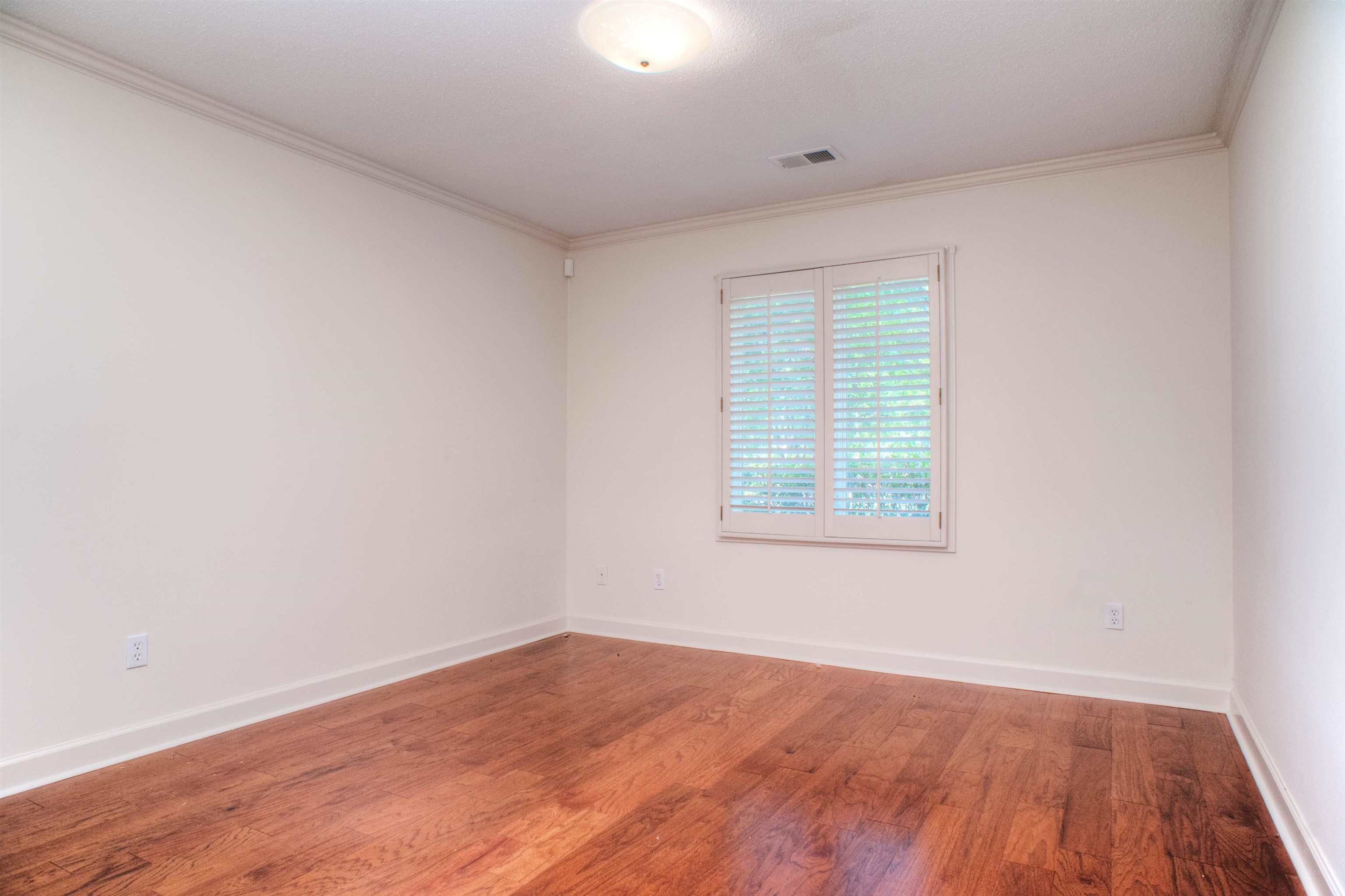 8225 Walnut Grove Road Memphis, TN 38018 - Photo 22 of 29 an empty room with wooden floor and windows