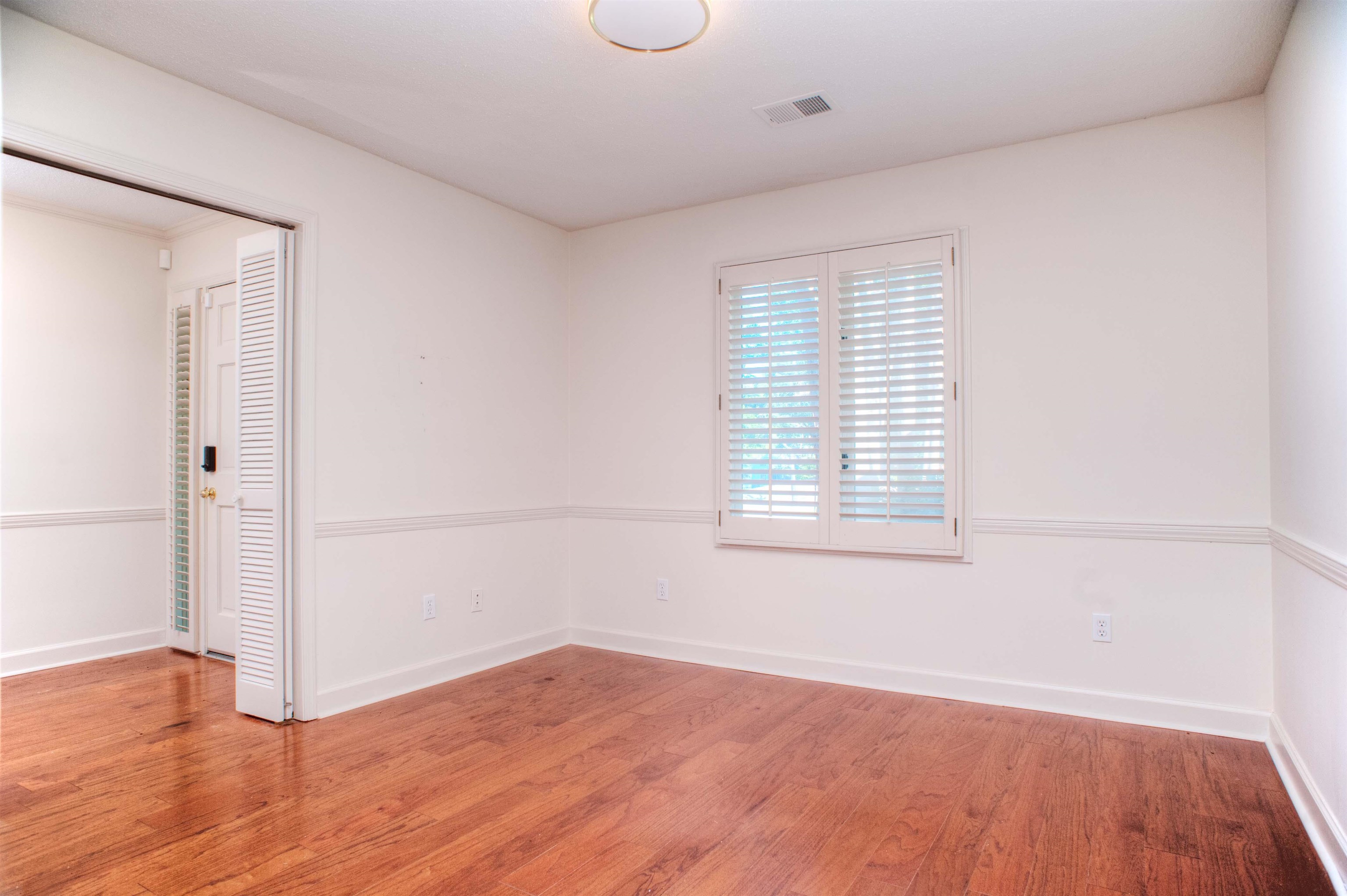 8225 Walnut Grove Road Memphis, TN 38018 - Photo 25 of 29 an empty room with wooden floor and windows