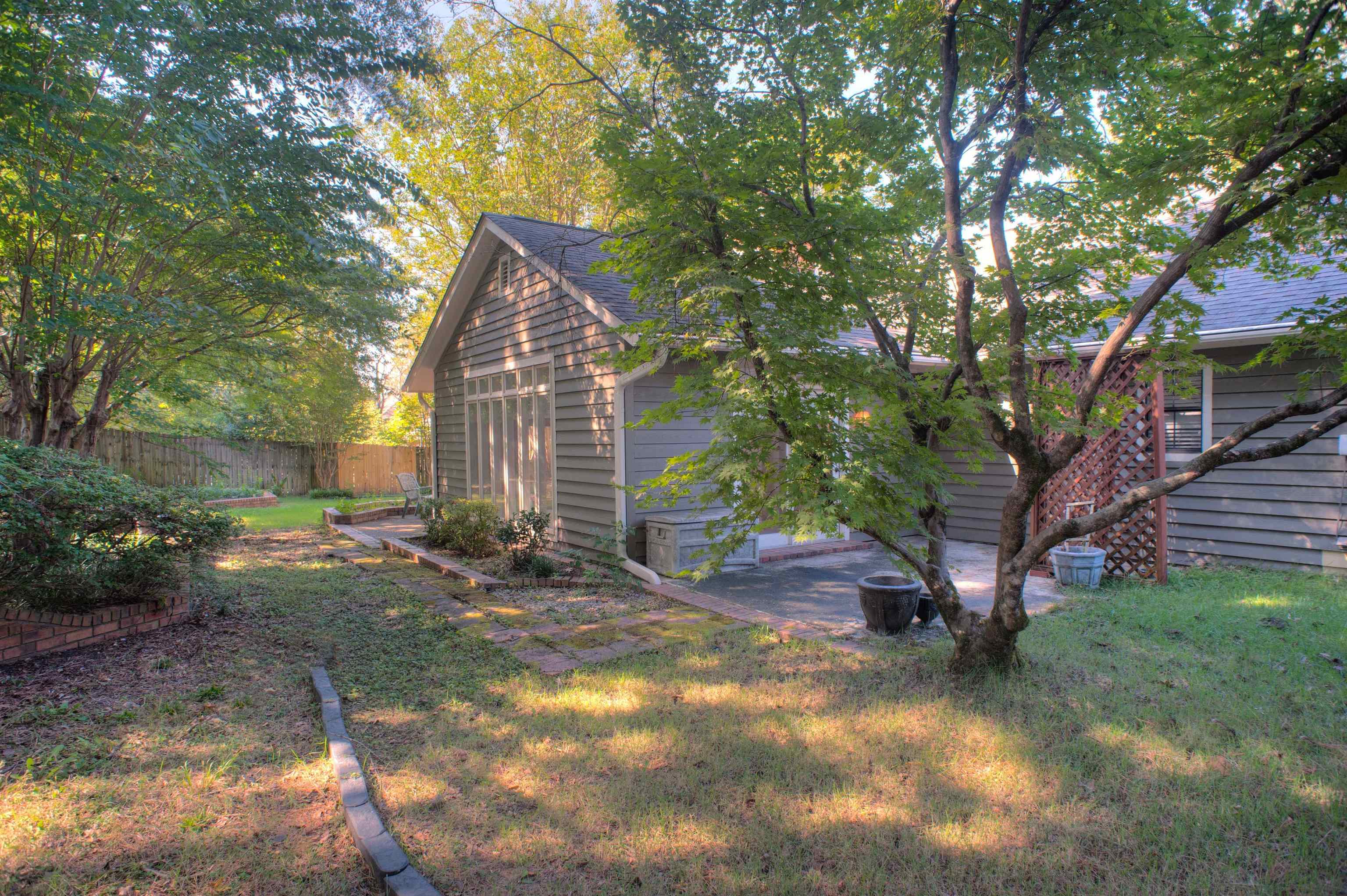 8225 Walnut Grove Road Memphis, TN 38018 - Photo 26 of 29 a backyard of a house with plants and large trees