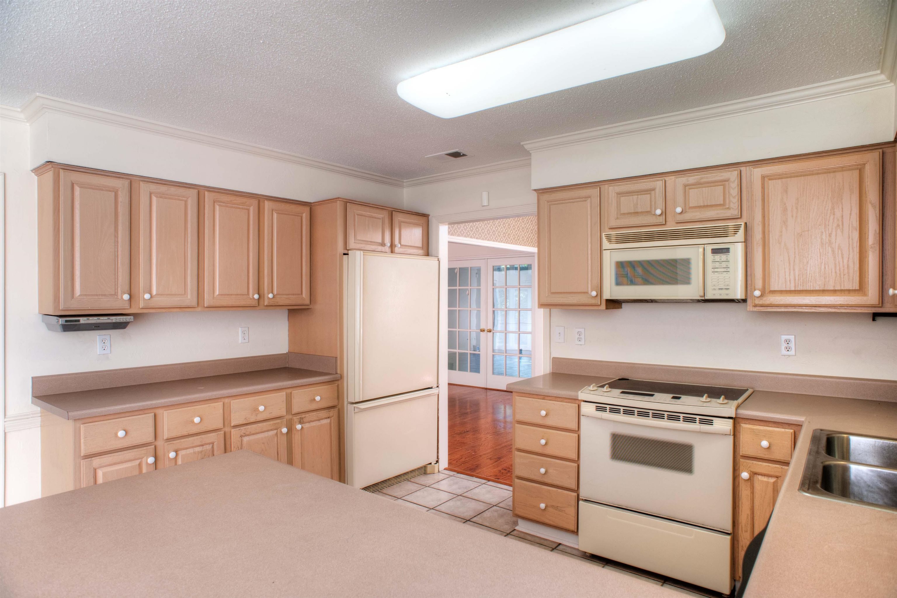 8225 Walnut Grove Road Memphis, TN 38018 - Photo 9 of 29 a kitchen with white cabinets and white appliances
